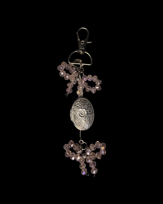 Coral bow captured the locket bag charm